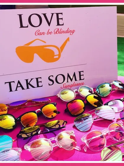 "Love can be blinding, take some sunglasses." A fun and practical favor station for a sunny outdoor event, ensuring guests are comfortable and stylish.