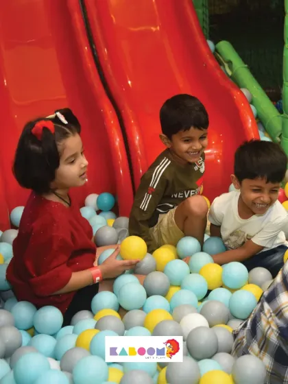 Friends sharing a fun moment after coming down the slide and landing in the ball pit.