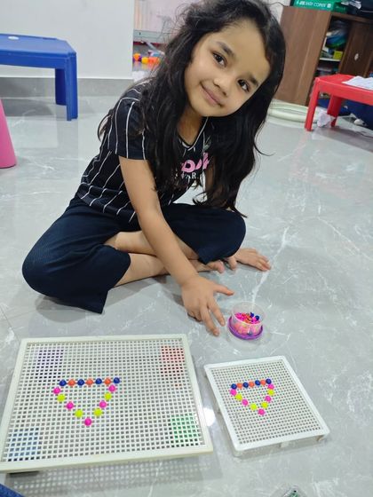Look at that focus. Using a pegboard strengthens the small muscles in the hand, improving the pincer grip that is essential for holding a pencil correctly.