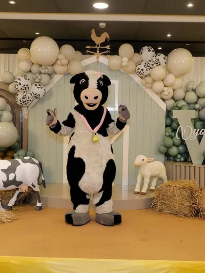 A cow mascot entertains the guests, bringing the farm theme to life and creating a fun photo opportunity.