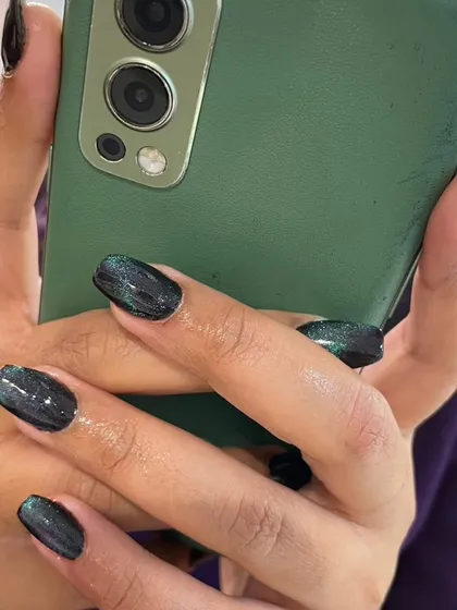 Here's a look at the mesmerizing cat eye effect on shorter, natural nails. This deep, shimmery polish catches the light beautifully, creating a dynamic and sophisticated look that's effortlessly cool.