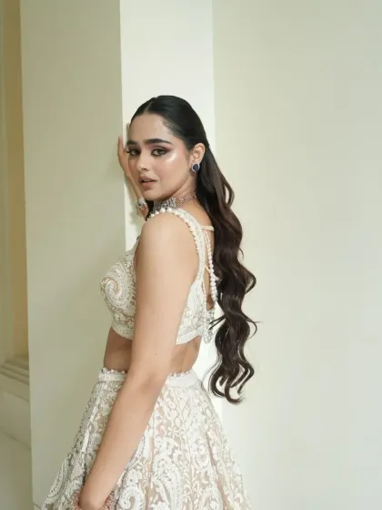 A side view showcasing the backless design of the blouse and the long, flowing hair. The styling is modern, glamorous, and perfect for a reception.