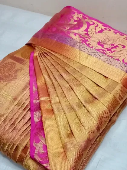 A rich gold and pink Kanjeevaram saree, pleated to showcase its grandeur.