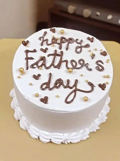 A simple and sweet Happy Father's Day cake with chocolate hearts and golden sprinkles.