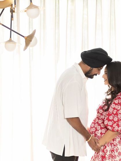 A tender moment of connection. The couple touches foreheads, their eyes closed, sharing a quiet and intimate moment during their cosy at-home photoshoot.