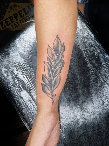 The finished leaf tattoo, which now serves as a beautiful and elegant cover-up for a previous name tattoo.