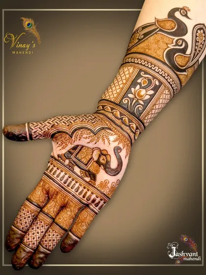 A close-up of the hand featuring the elephant motif, surrounded by intricate line work and topped with peacocks on the wrist.