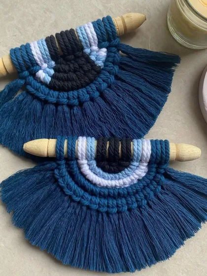 A detailed view of our macrame evil eye wall hangings. We use multiple shades of blue cord to create depth and texture in this protective symbol.