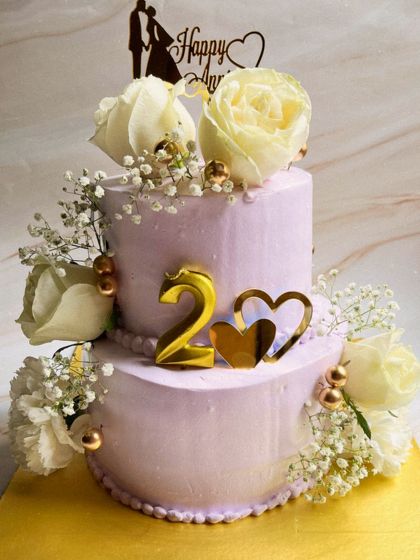 Celebrating two years together with this beautiful two-tier butterscotch cake. We decorated this lavender anniversary cake with fresh white roses, baby's breath, and gold accents for a touch of romance.