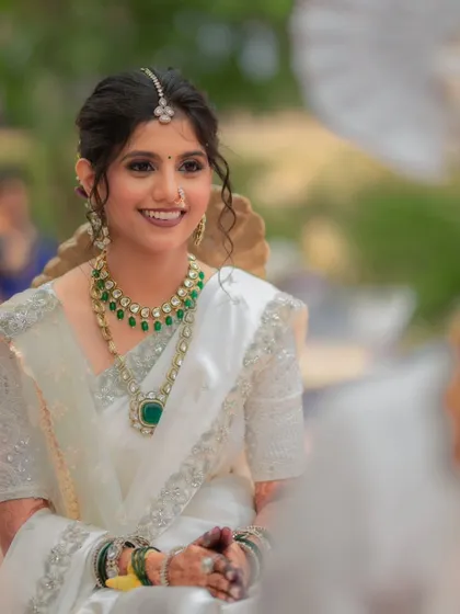 A radiant bride smiling during her wedding ceremony. The natural light beautifully highlights her glowing skin and the soft, elegant makeup I created for her.