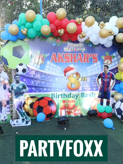 An elaborate football birthday bash for Akshar, featuring cutouts of star players, a stadium backdrop, and colorful balloon arrangements.