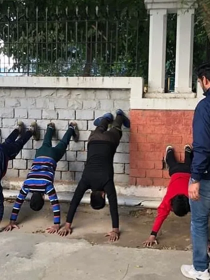 Building a champion's body. Physical conditioning, like these wall handstands, is a core part of our training to build stability and strength.
