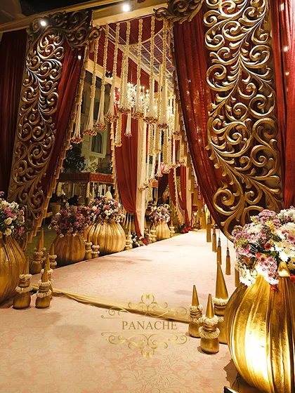 The entrance to the royal affair, lined with oversized golden vases and lush floral arrangements. We design these pathways to build anticipation and immerse guests in the theme from the moment they arrive.