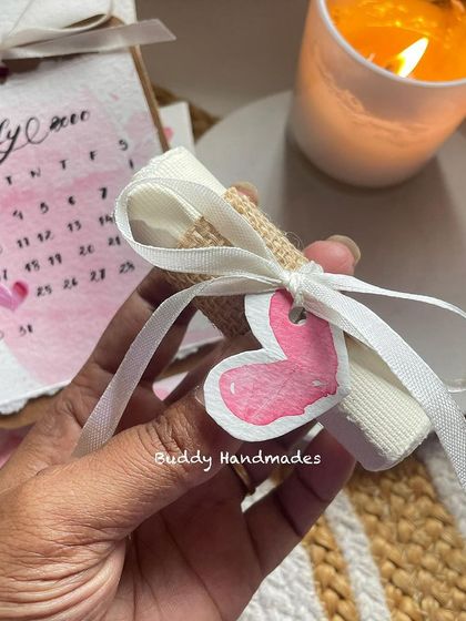 A tiny rolled-up message with a heart tag, part of a larger birthday gift set. It's the little details that count.