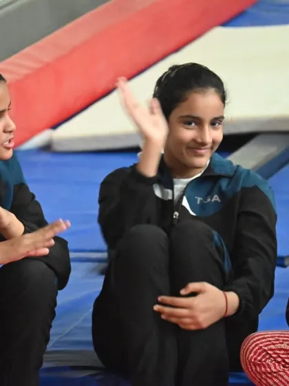 Friends and teammates. Our gymnasts share a laugh during a break, showcasing the fun side of our community.