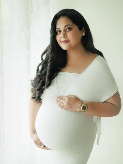 A simple, beautiful portrait of a glowing mother-to-be. Her direct gaze and gentle smile are so captivating in this classic studio shot.