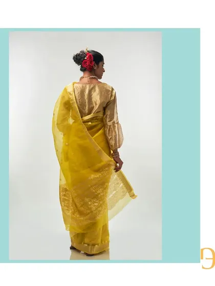 The back of the cadmium yellow saree, showing the beautiful fall of the organza and the rich detail of the pallu.