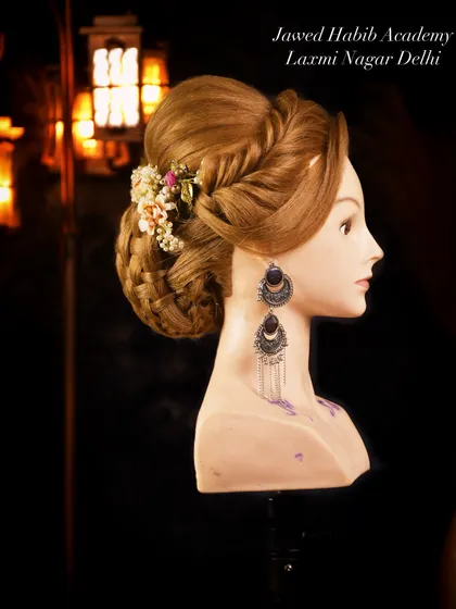 A side-swept braided updo with floral accents and statement earrings. This look combines multiple techniques, including braiding and bun-making, for a beautiful result.
