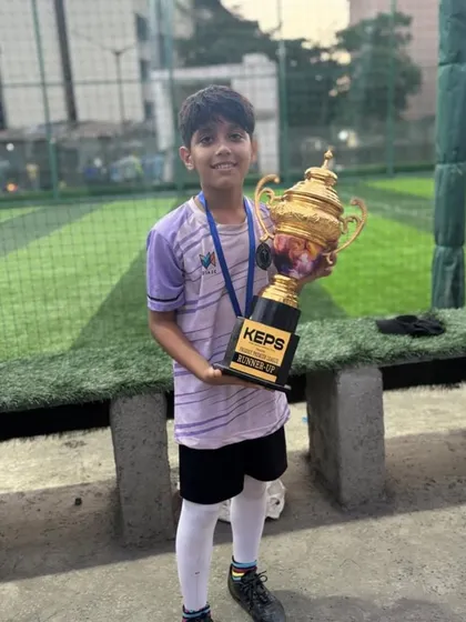 A young champion from our U-15 squad holding the runner-up trophy from the Prodigy Premiere League.