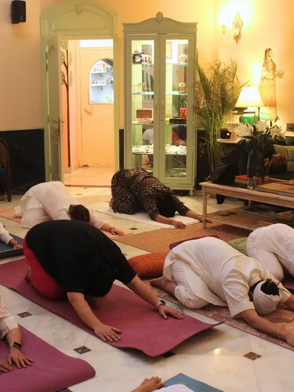 Participants in a deep, surrendering posture during a yoga session in Jaipur. This posture, known as Guru Pranam, helps us to bow to our own inner wisdom and release the ego.
