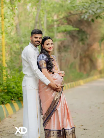 Embracing tradition with grace. This outdoor couple's portrait captures the elegance of a classic silk saree, blending cultural heritage with the natural beauty of a park setting for a timeless maternity photo.