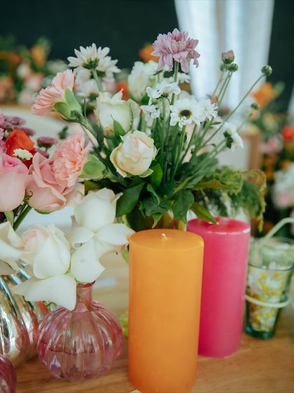 A detail shot of the vibrant candles and fresh flowers used in the 'Nazar Na Lage' decor.