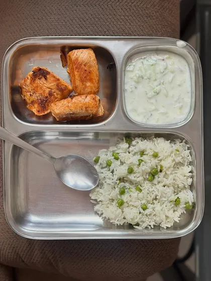A simple meal of peas pulao, pan-fried salmon, and raita. Salmon is a great source of protein and healthy omega-3 fats.