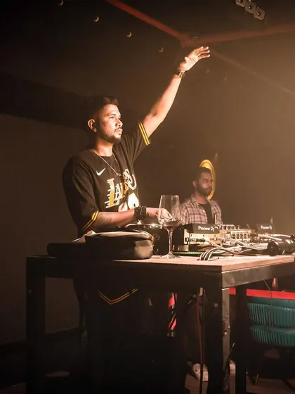 A classic DJ pose at Cyclone Club in Nagpur, with one hand up, feeling the energy of the room.