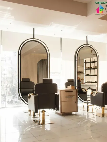 The salon's interior is bright and airy, with high ceilings and a white marble-finish floor that reflects light throughout the space.