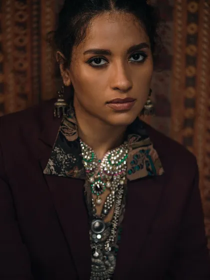 This direct-to-camera shot showcases how statement jewellery can frame the face. The rich, warm tones complement the traditional design of the pieces.