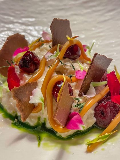 Riz Au Lait, a sophisticated take on rice pudding. I use Arborio rice and pair it with dulce de leche, sour cherries, and a fig leaf oil for a unique flavor profile.