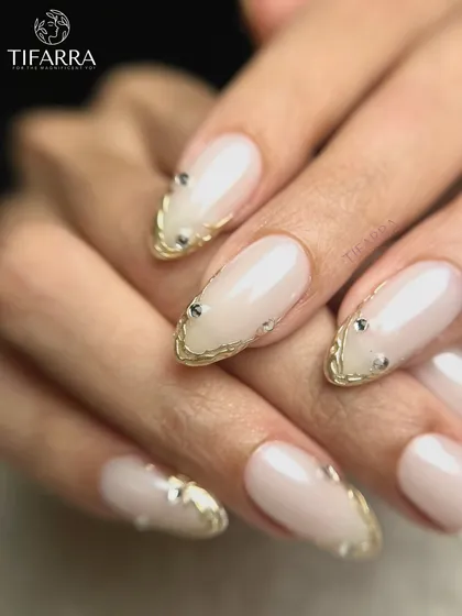 A close-up of the pearl-finished nails, highlighting the delicate gold border and the shimmer of the base color.
