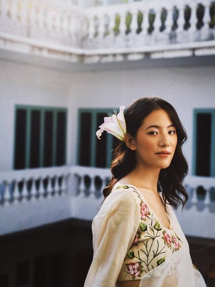 An elegant portrait for Baavli, taken against a classic architectural backdrop. The model's serene expression complements the delicate embroidery of her outfit.