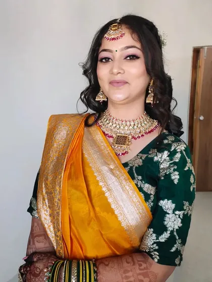The complete look with the yellow saree and green blouse. The makeup perfectly complements the vibrant colours of her outfit.