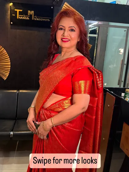 A gorgeous mother of the bride in a classic red saree. The makeup is elegant and enhances her natural grace.