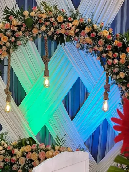 The combination of a lush floral arch and rustic rope-hung Edison bulbs creates a popular modern-rustic aesthetic.