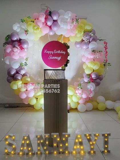 A lovely pastel-themed balloon ring with marquee letters, perfect for a personalized birthday celebration.