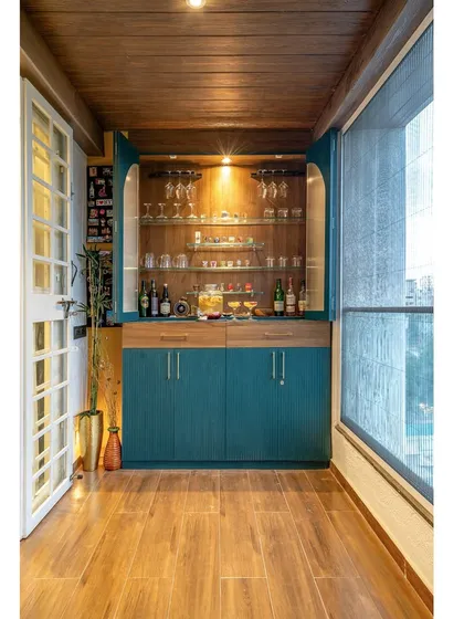We believe every part of a home can be beautiful and functional. This balcony was transformed into a sophisticated bar, complete with custom teal cabinetry, integrated lighting, and elegant glassware storage, creating the perfect nook for evening relaxation.