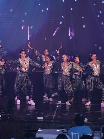 The full dance crew in our "Jhoome Jo Pathaan" performance. We use stage lighting and synchronized movements to create a professional and visually engaging show for the audience.