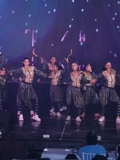 The full dance crew in our "Jhoome Jo Pathaan" performance. We use stage lighting and synchronized movements to create a professional and visually engaging show for the audience.