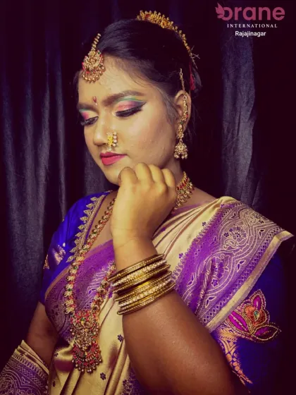 This close-up highlights the detailed hair and makeup for a festive look. The hair is pulled back neatly to accentuate the facial features and traditional jewelry, a technique our students master.