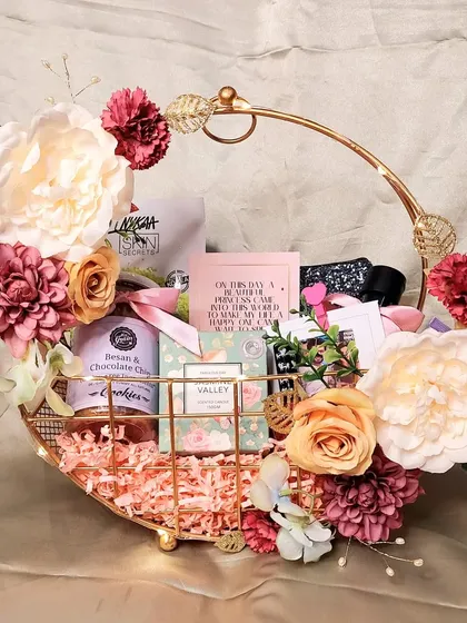 A beautiful and versatile 'Gift for Her' hamper. This floral metal basket is filled with skincare, cookies, and other pampering items, making it a perfect gift for a birthday, Mother's Day, or just because.