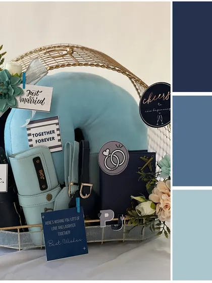 Another take on the "Something Blue" theme. This hamper is elegantly arranged in a gold wire basket and includes personalized travel wallets, luggage tags, and a comfy neck pillow for their honeymoon.