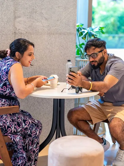 A couple sharing a moment over their phones and coffee. Our cafe is a great spot for both digital and real-life connections.