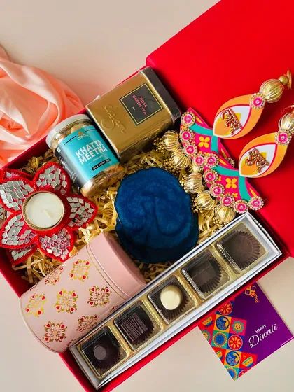 An angled view of the classic red box, showing the variety of premium items packed inside, from gourmet chocolates to festive decor.