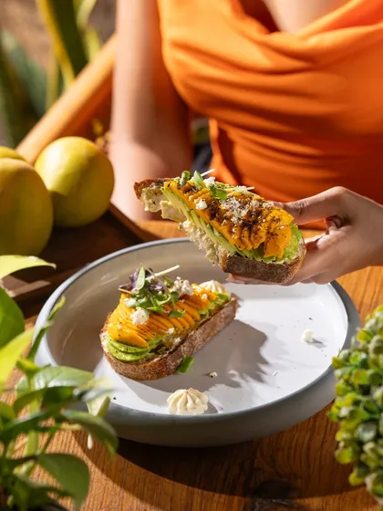 Sharing a mango avocado toast. This image highlights the social, shareable nature of the food.