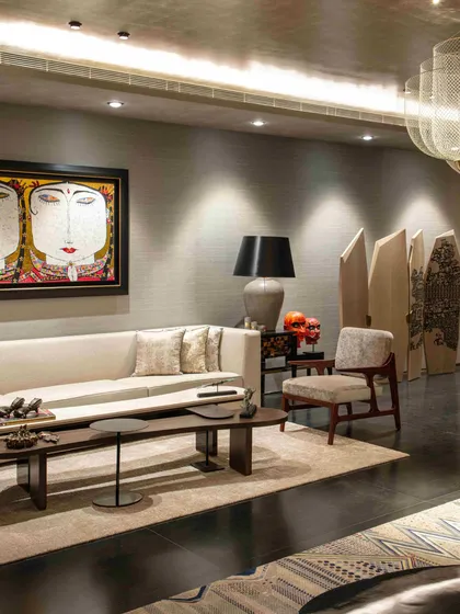 A seating area in the formal living room featuring a neutral sofa and a large, expressive painting. The space is designed for conversation, with furniture arranged to create intimate groupings.
