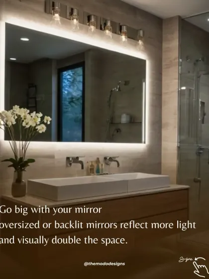 Go big with your mirror. An oversized or backlit mirror, like the one shown here, reflects more light and can visually double the size of your bathroom.