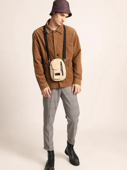 A street-style inspired look from an editorial shoot. A corduroy jacket is paired with houndstooth trousers, a bucket hat, and a crossbody bag for a trendy, layered outfit.