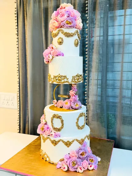For grand celebrations, I create cakes that are as breathtaking as the moment itself. This four-tier floral wedding cake, with its floating tier and cascading handmade flowers, is a testament to timeless elegance.